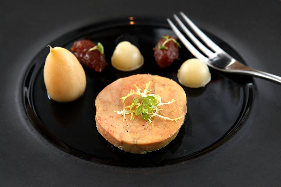 Présentation élégante d'une tranche de foie gras mi-cuit sur assiette noire