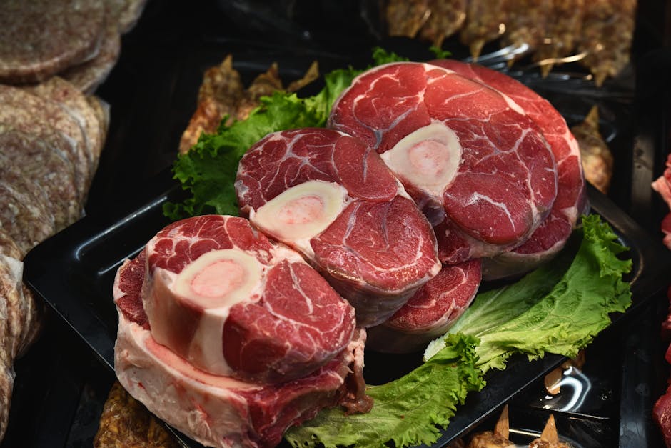Gros plan d'un osso buco frais et cru exposé avec des feuilles de laitue verte.